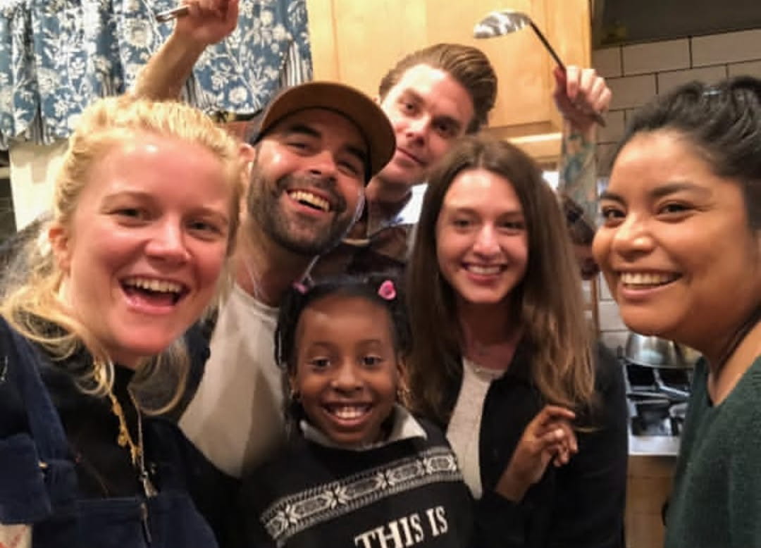Craig, Mereki, and Kristin having fun with the Alexandria House community in a kitchen